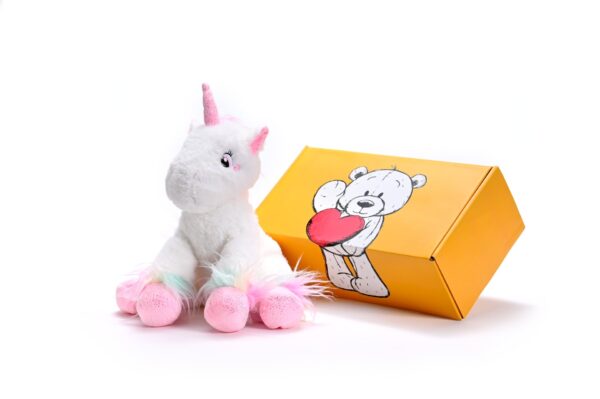 a stuffed unicorn soft toy next to a box